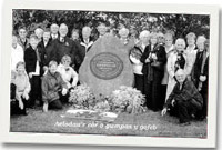 Aelodau o'r côr o gwmpas y gofeb