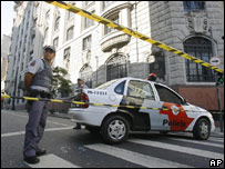 Policial em frente a prédio do governo em São Paulo após ataque atribuído ao PCC em agosto 