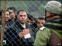 Palestinos mostram identidade na fronteira para soldados israelenses