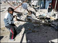 Garoto olha destroços de atentado em fevereiro em Bagdá