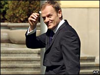 Polish PM Donald Tusk waving a daisy