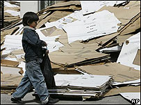 Garoto caminha ao lado de material usado na eleição.