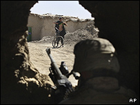 یک نوجوان هلمندی، برای اطمینان سرباز ناتو از نداشتن بمب انتحاری، پیراهن خود را بالا می زند