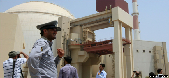 An Iranian security man stands next to journalists outside the reactor building at the Russian-built Bushehr nuclear power plant in southern Iran 
