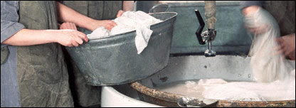 Laundry being washed by hand as it was in the old wash houses
