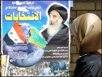 Şii lider Sistani'nin fotoğrafının bulunduğu seçim posterine bakan bir kadın
