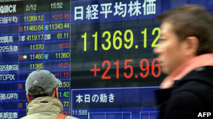 日本东京街头民众走过股价显示屏幕（12/2/2013）