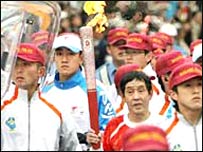 जापान के नागानो शहर में सुरक्षा के बीच मशाल