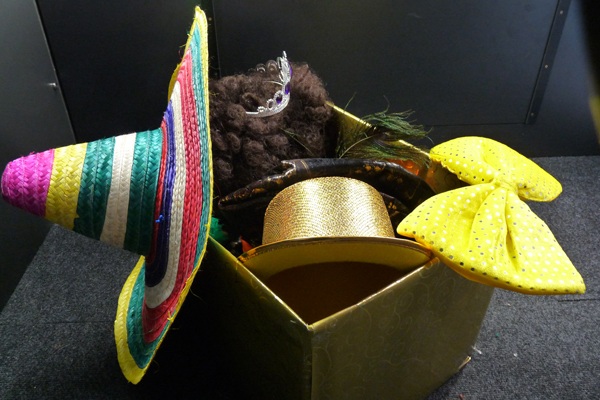 A box full of props including hats and bow-ties