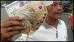 A man holding Indonesian currency, rupiah