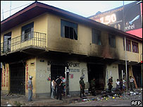 Policiais guardam a frente de uma loja saqueada em Cobija, em Pando, Bolívia