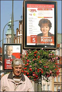 مردی در مقابل پوسترهای انتخاباتی در لهستان