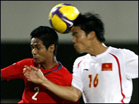 Cầu thủ Việt Nam trong một pha tranh bóng với tuyển thủ Singapore