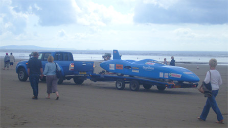 The electric car is towed off the sands for repairs. Image by Rachael Garside.