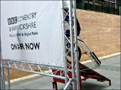 A stunt motorbike bursts through a paper sign