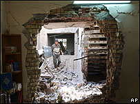 Iraquiano caminha pelos destroços de sua casa, em Falluja, atingida por um morteiro no combate de segunda-feira