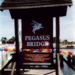 Replica 'Pegasus Bridge' sign next to the Gondrée café and Caen Canal, 23 July 2004, almost sixty years to the day after 'Operation Mosquito'. In 2004 the owner was Madame Arlette Gondrée-Pritchett, daughter of the owners in 1944.