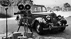 Photograph of a camera and a 1950s car