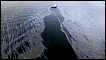 A boat with an oil boom tries to contain oil spilled from the explosion and collapse of the Deepwater Horizon oil rig in the Gulf of Mexico (23 April 2010)