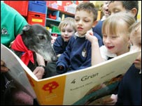Scotts the dog being read to by some kids.