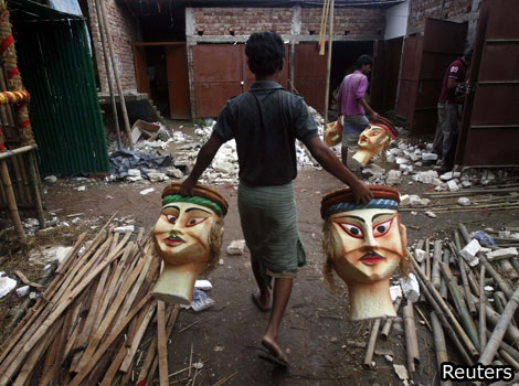 A man carries polystyrene heads for the Durga Puja festival in India.