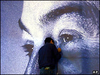 Muž, kterývylepuje plakát Ajáda Alávího