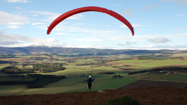 Paraglider launching from hilltop