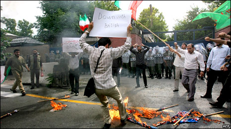A demonstrator holds a placard reading 'Down with British' as protestors burn flags outside the British embassy in Tehran on June 23, 2009