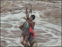 Garoto é retirado de enxurrada