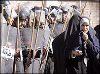 رای دهنده مصری از برابر صف پليس ضدشورش می گذرد