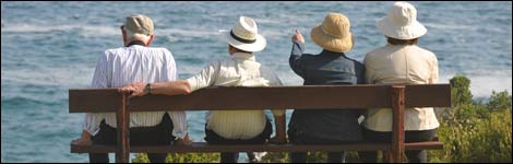 Old people sitting on a bench overlooking the sea
