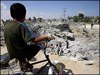 Menino palestinos inspecionam casa destruída