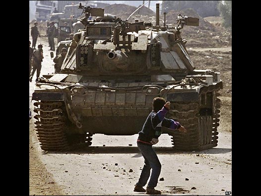 Un niño lanza una piedra contra un tanque israelí