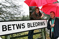Nia Robets a Trevor Fishlock gydag arwydd Betws Bledrws