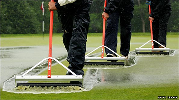 Greens staff attempt to clear standing water at Bethpage