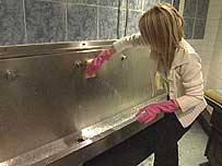 Woman cleaning urinal
