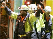 Mineiros acenam para pessoas 