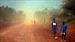 Two boys walking on a dusty road