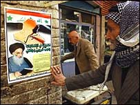 Sistani'nin posterine bakan bir Iraklı