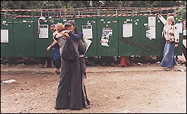 Two friends greeting each other outside the Glasto toilets