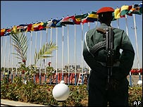 Một binh lính đứng gác bên các cột cờ các nước LH châu Phi