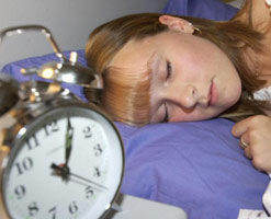 Woman sleeping next to clock