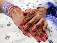 Woman wearing white dress with Henna on hands