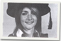 Dr Alexi Glover yn ei gŵn graddio