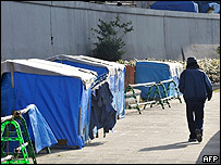 Sem-teto caminha perto de barracas de outros sem-teto em Tóquio