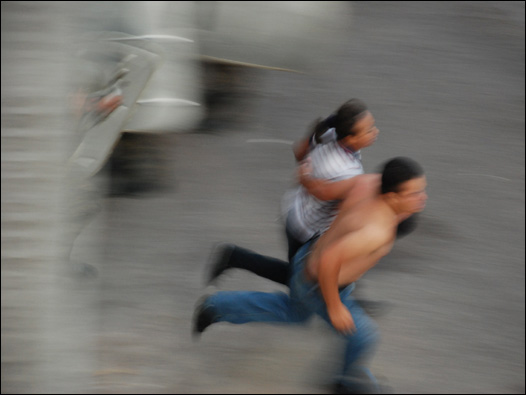 Manifestantes corren cerca de la sede de la ONU en Tegucigalpa
