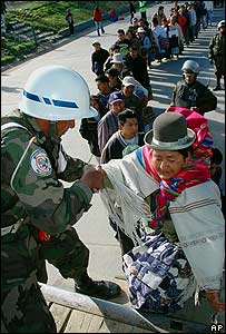 Soldado boliviano ajuda senhora 