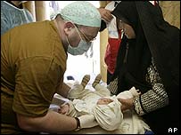 Médico examina bebê em hospital improvisado em Bam, no Irã