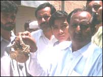 مقامی افراد جلے ہوئے اوراق دکھاتے ہوئے