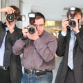 Three paparazzi photographers snapping away at a celebrity